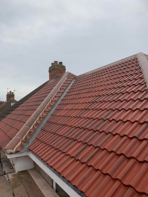 This is a photo of a new roof replacement covered in red tiles. This roof installation was done by Leicester roofing Services